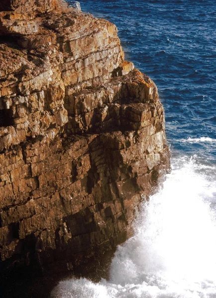 Cliff with splashing sea waves at daytime