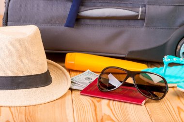 aksesuar ve gerekli belgeler için bir ahşap zemin yakın çekim gri bavula arka plan üzerinde seyahat