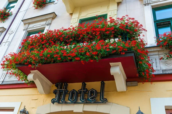 Balcón Con Hermosas Flores Rojas Letrero Hotel Por Encima Entrada —  Fotos de Stock