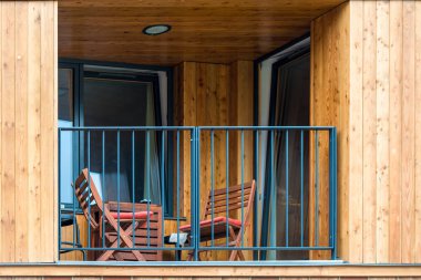 o ve dinlenmek için bir masa sandalye ile bir ahşap evin balkon