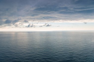 Hafif bir dalgalanma ile deniz yüzeyi, ufuk ve yoğun siyah yağmur bir görünümü güzel bir manzara bulutlar.