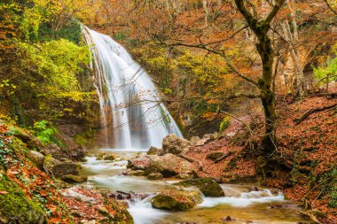 Sonbaharda dağlardaki Jur-Jur şelalesinin yatay fotoğrafı, Kırım yarımadasının doğal manzarası.
