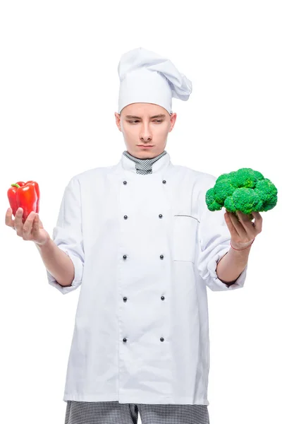 Cozinheiro Escolhe Entre Vegetais Pimenta Brócolis Retrato Fundo Branco — Fotografia de Stock