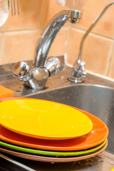 台所の蛇口とシンクの背景にきれいなプレートのスタック — ストック写真