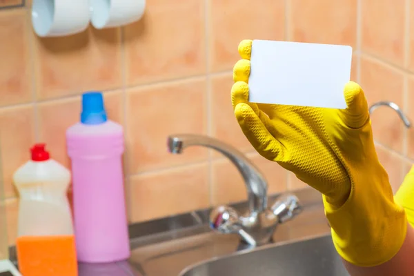 home and kitchen cleaning service - blank in hand, wearing a yellow glove. close-up