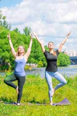 Parkta temiz havada egzersiz yapan olgun bir kadın, bireysel antrenörle nişanlanır.