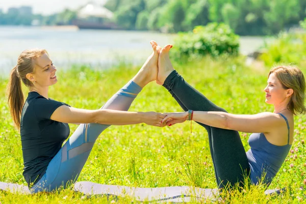 在公园里和一位教练一起做瑜伽伸展运动的成熟女人 — 图库照片