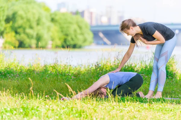 在一位经验丰富的教练的指导下进行瑜伽练习 在公园里进行户外运动 — 图库照片
