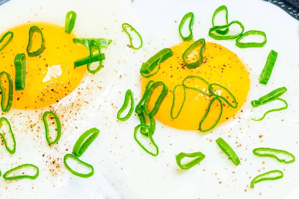 从一个平底锅中的两个鸡蛋和绿色洋葱中关闭自制的炒鸡蛋 — 图库照片