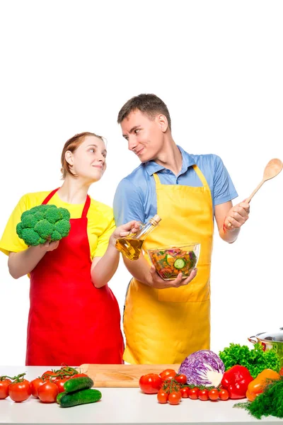 Молодая пара смотрит друг на друга в любви во время приготовления овощей — стоковое фото