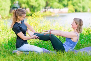 Parkta deneyimli bir antrenörle yoga egzersizi.