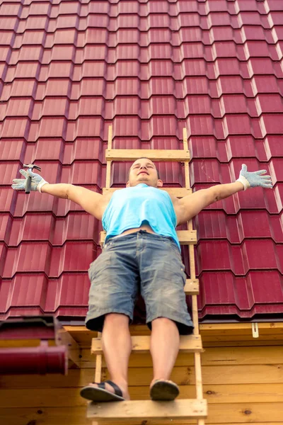 stock image portrait of a repairman on a ladder on the roof while resting fr