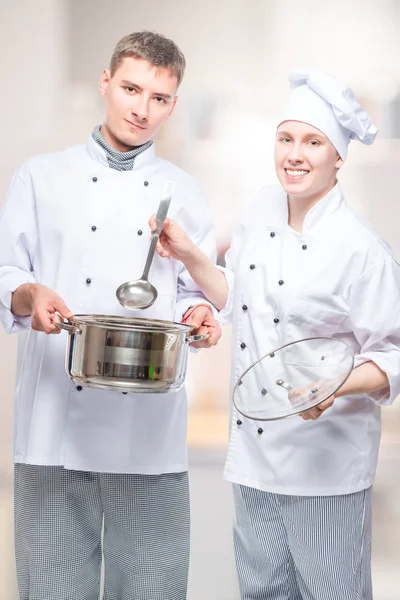 Cocineros profesionales exitosos con una sartén y un cucharón en un comensal —  Fotos de Stock