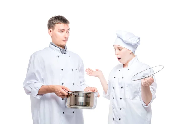 Cuisinier surpris regarde la soupe dans une casserole d'un autre chef sur un blanc — Photo