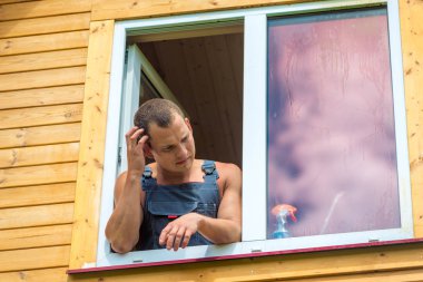 Tulum içinde Pensive adam ho pencere yıkama yansıtır