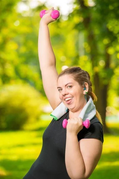 Satisfied plump woman doing her exercise in the park, exercise w — Stock Photo, Image