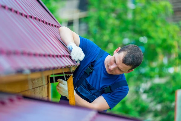 Een man met gereedschap tijdens de reparatie van het dak van het huis — Stockfoto