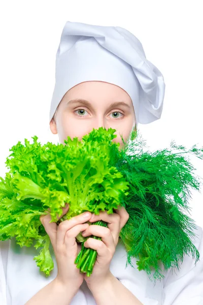 Chica chef en una gorra con un montón de lechuga y eneldo en un b blanco —  Fotos de Stock