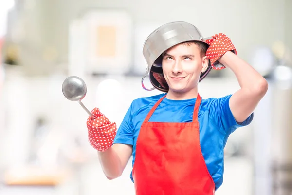 crazy man in a red apron put a pan on his head and posing in the