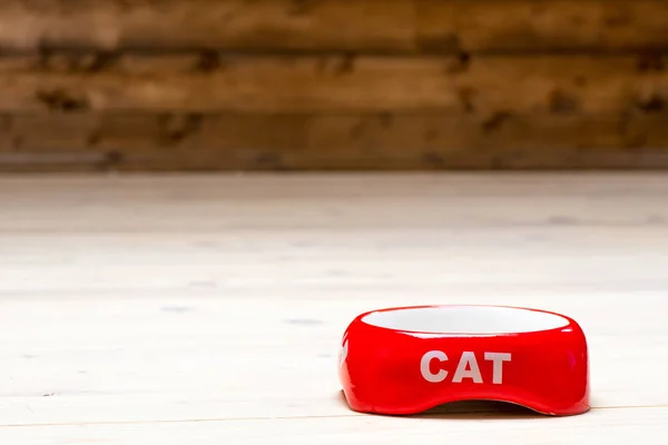Кошачья красная миска пустая на полу в доме, пространство сверху — стоковое фото