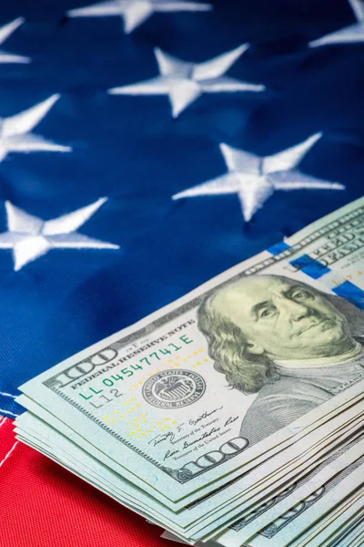 Vertikal fotovy av en bunt pengar liggande på flaggan av — Stockfoto