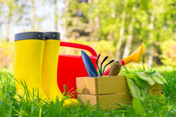 Attrezzi da giardino, annaffiatoio e stivali da giardiniere primo piano nel — Foto Stock