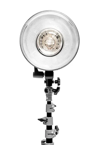 Potente lámpara flash de fotos en rack sobre fondo blanco en el estudio — Foto de Stock