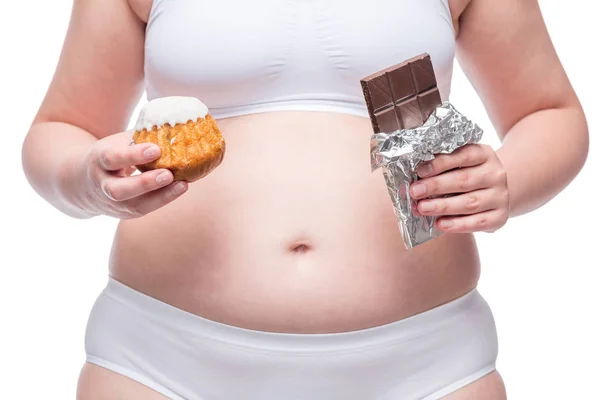 Menina gorda com chocolate e muffin em roupa interior, barriga close-up — Fotografia de Stock