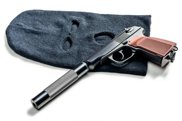 Schwarze Sturmhaube und eine Pistole mit Schalldämpfer in Nahaufnahme auf einem weißen — Stockfoto