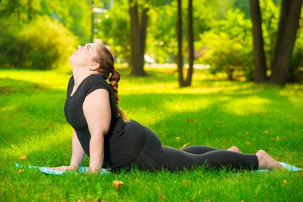 Work on yourself - a sports woman plus size in the park performs — Stock Photo, Image