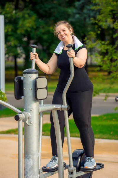 Aktive, dicke Frau ohne Komplexe ist auf der Stepper-Simulation beschäftigt — Stockfoto