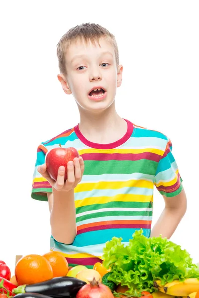 Vertical portrait of a boy with a red ripe apple in the studio o — Stock Photo, Image