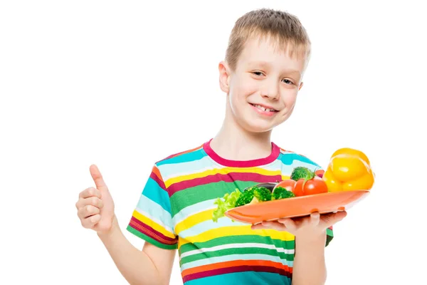 Satisfait garçon avec une assiette de légumes sains isolés sur whi — Photo