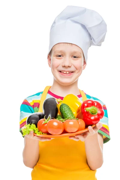Boy cook in a cap with a plate of ingredients - healthy vegetabl — Stock Photo, Image