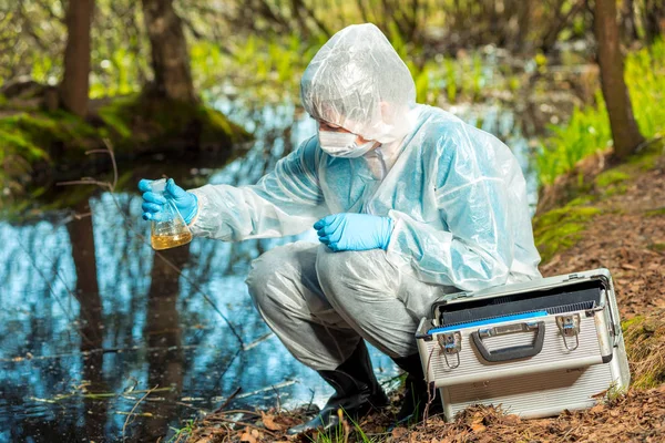 Amostragem de água por um ecologista experiente de um rio florestal — Fotografia de Stock