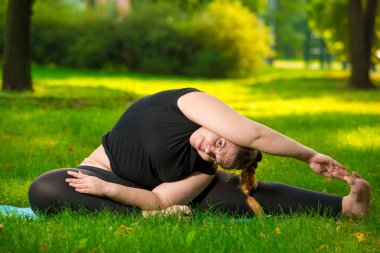 esnek artı boyutu kadın çim üzerinde parkta yoga yapıyor