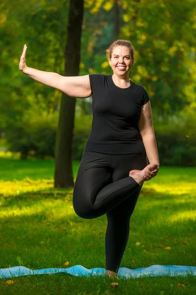 Overgewicht vrouw stretching in het Park. — Stockfoto