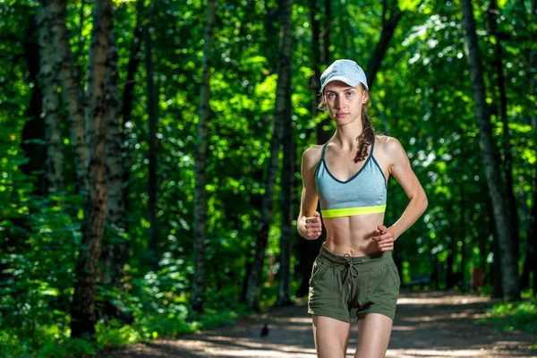 Retrato de una hermosa deportista musculosa mientras trota en un —  Fotos de Stock