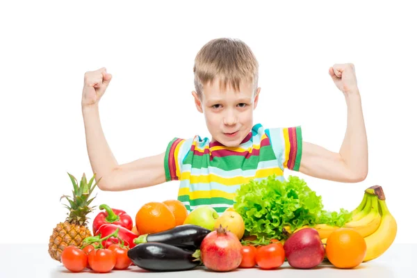 Petit homme fort montre biceps à la table avec un tas de v frais — Photo