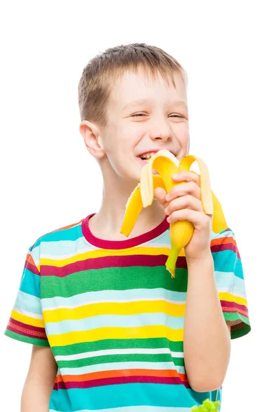 Ritratto verticale di un ragazzo che mangia una gustosa banana su una ba bianca — Foto Stock