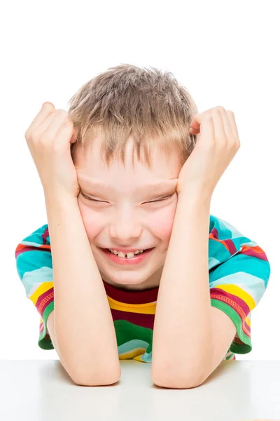 Verticaal emotioneel portret van een jongen van 10 jaar aan de tafel op — Stockfoto