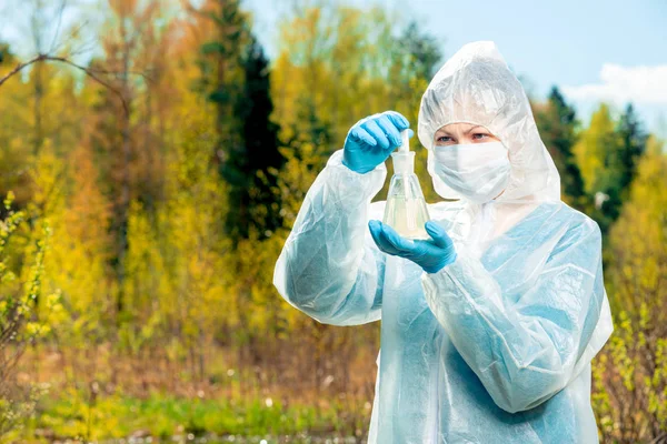 Een wetenschapper bestudeert de samenstelling van water uit een bosmeer — Stockfoto