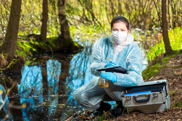 Biologista bere vodu z Lesní řeky ke studiu kompozit — Stock fotografie