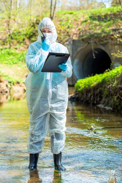 a female scientist with a walkie-talkie and a notebook fixes env