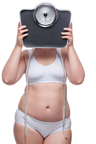 Fat woman in underwear covers her face with scales, portrait is — Stock Photo, Image