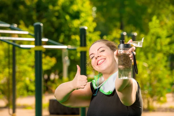 Femeie supradimensionată fericită cu o sticlă de apă zâmbește, portret afte — Fotografie, imagine de stoc