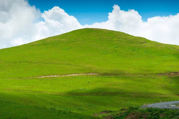 Hermosa colina plana verde sobre un fondo de cielo azul en un claro — Foto de Stock