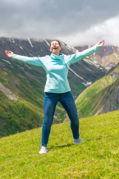 Emotional woman with open arms in the mountains enjoys freedom — Stock Photo, Image