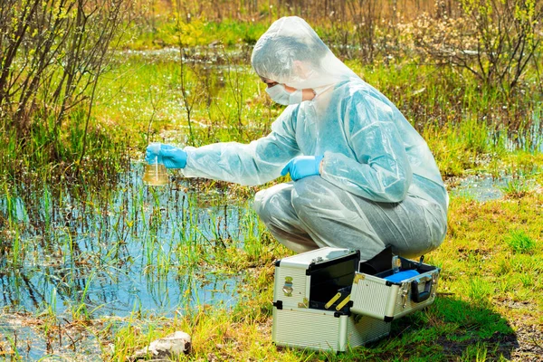 Environmentalista na břehu lesního jezera bere vodu vzorku — Stock fotografie