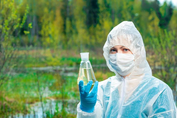 Ecoloog en gevaarlijk dood water uit een bosmeer in een kolf — Stockfoto